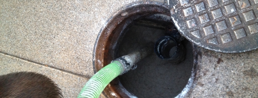 An overhead view of a man cleaning a grease trap